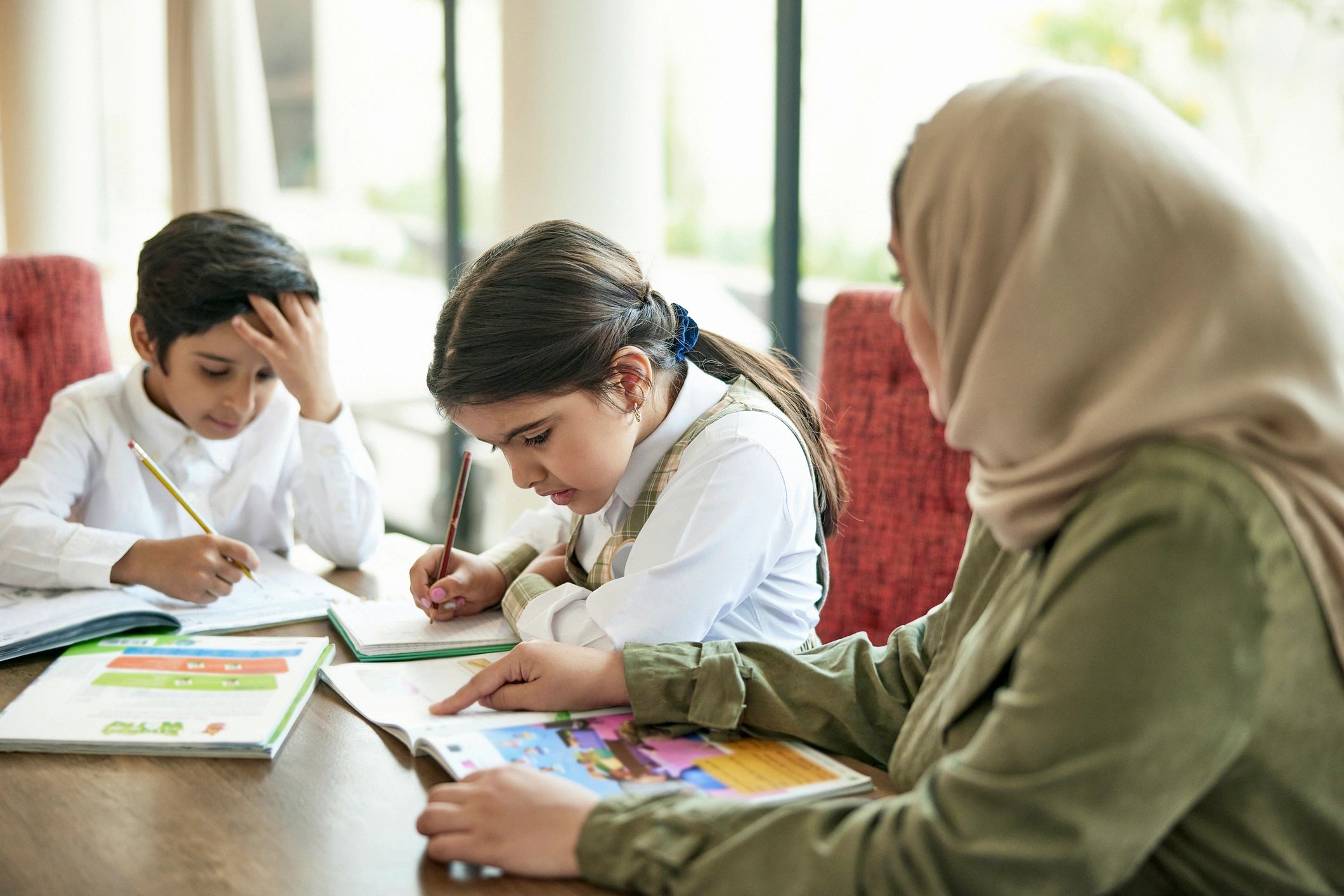 أسرة تتلقى دعماً تعليمياً داخل المنزل بما يعكس الرعاية والتنمية